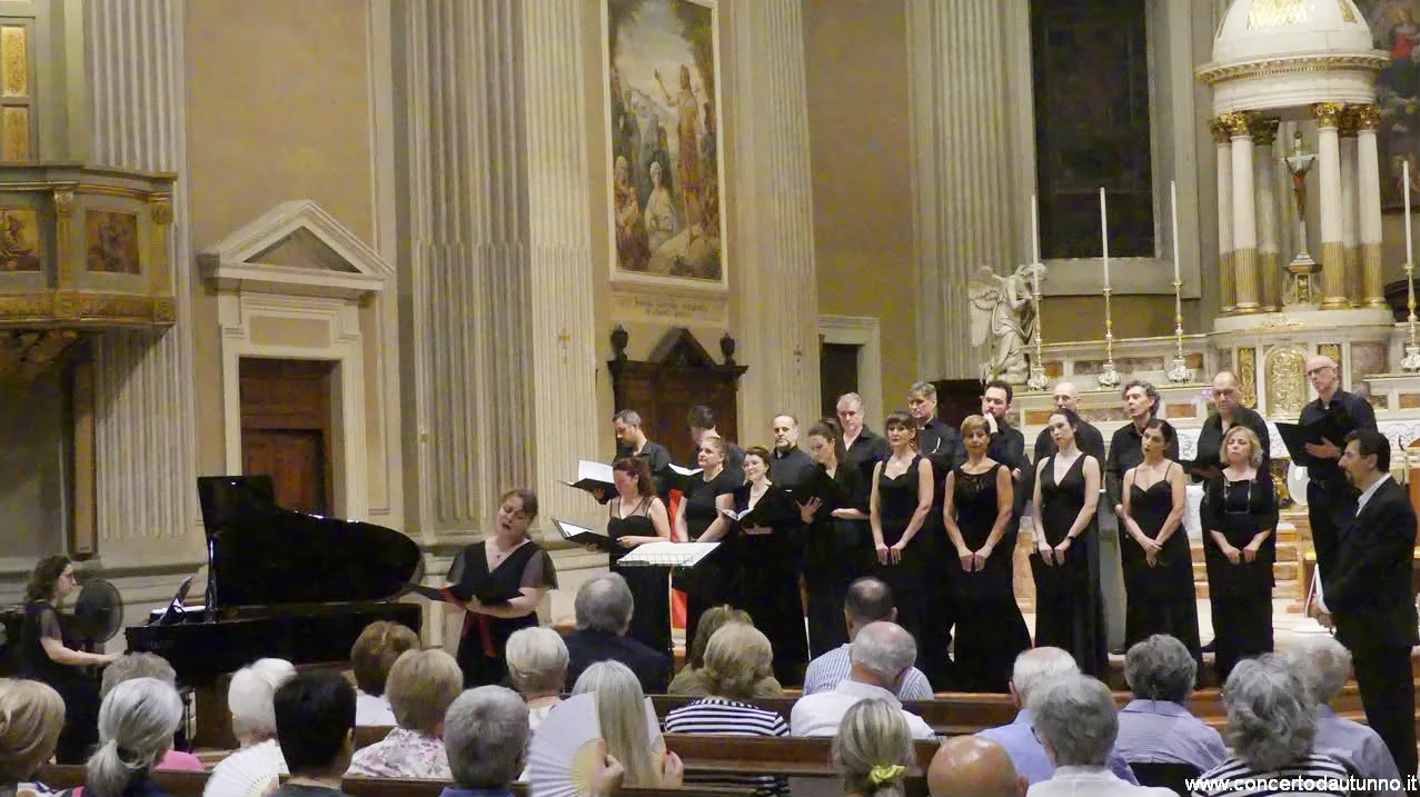 Una solista canta davanti al coro, accompagnata al pianoforte, in una chiesa piena di pubblico